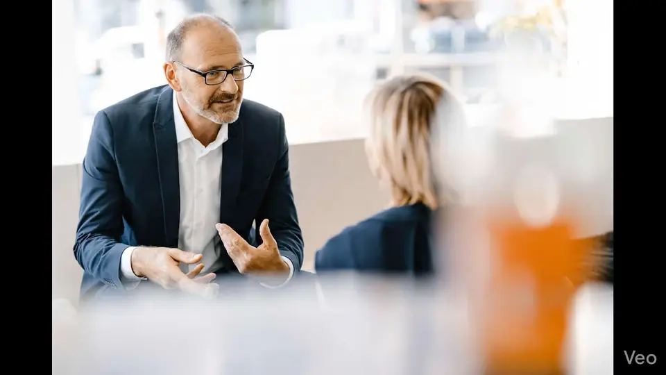 Executive mentor in conversation with a senior leader in a private office